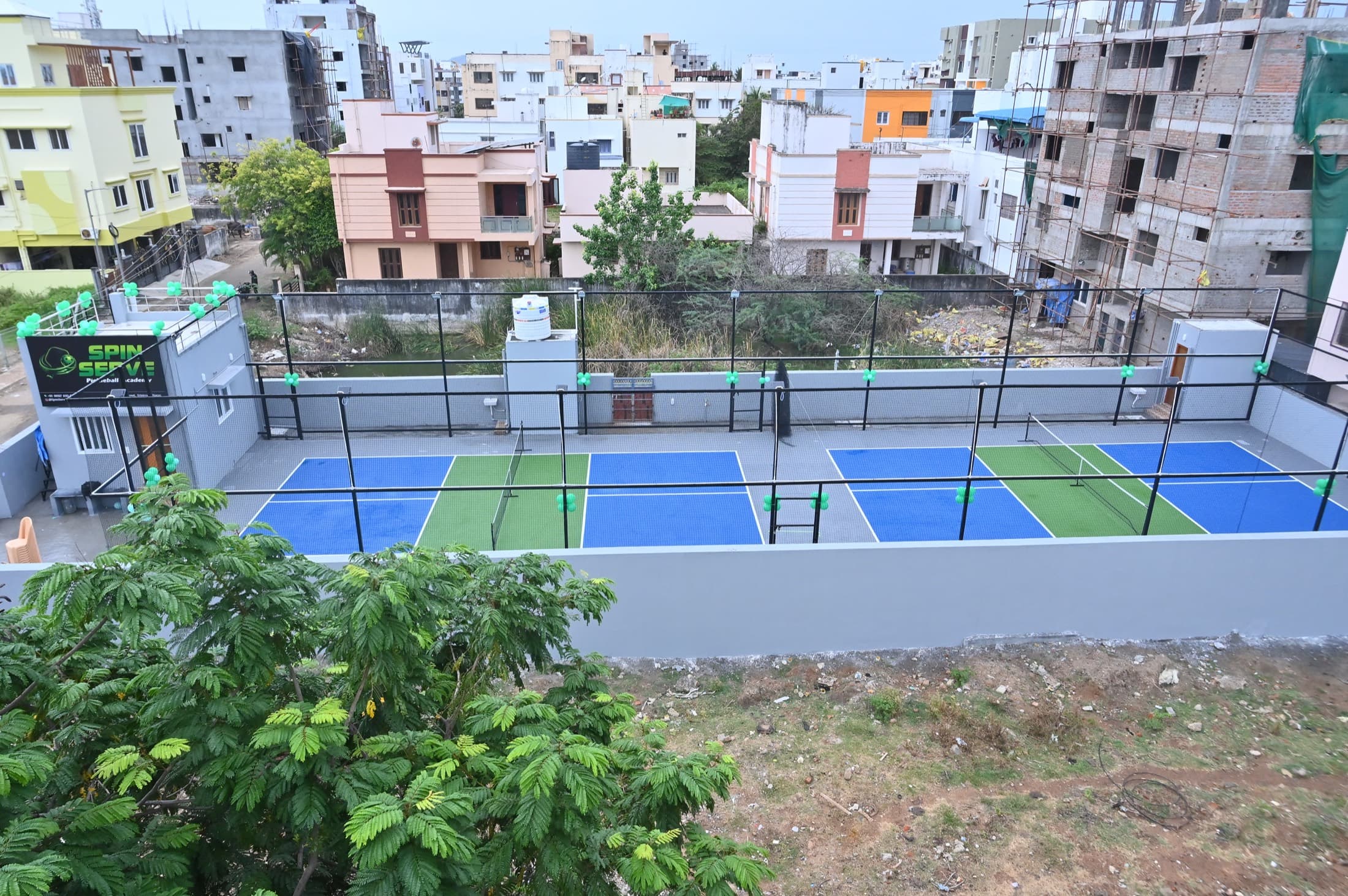 Both courts from above, set among the houses of Srinivasa Nagar in Madipakkam