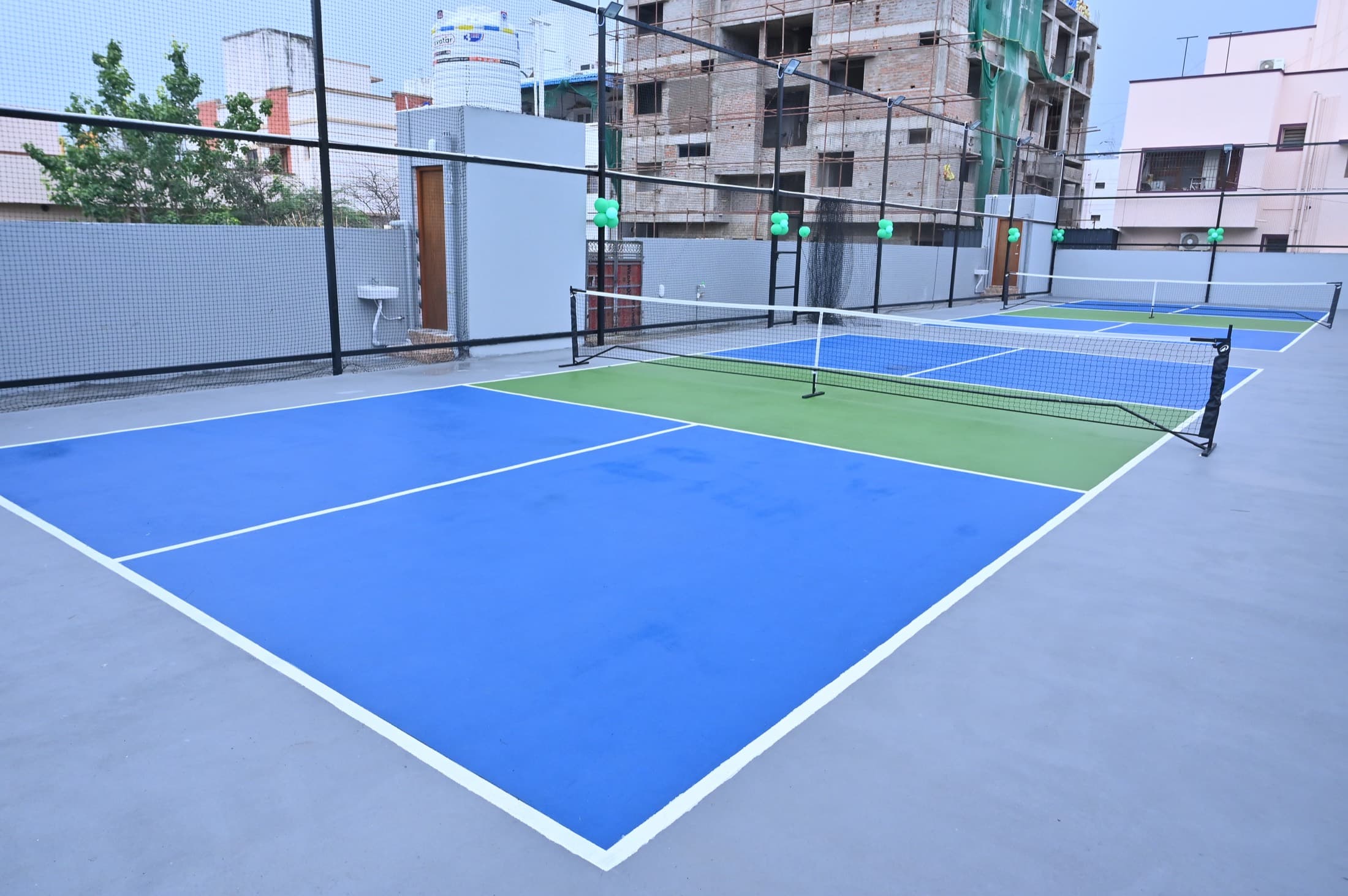 The two courts from the opposite end, showing the full playing area and the perimeter fencing